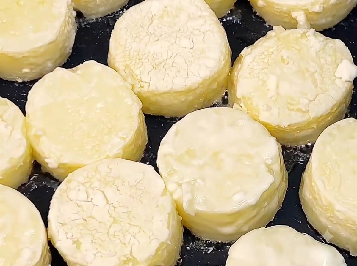 Rondelles de tofu japonais en train de frire dans lhuile chaude dans une poêle noire jusquà ce que les surfaces deviennent dorées.