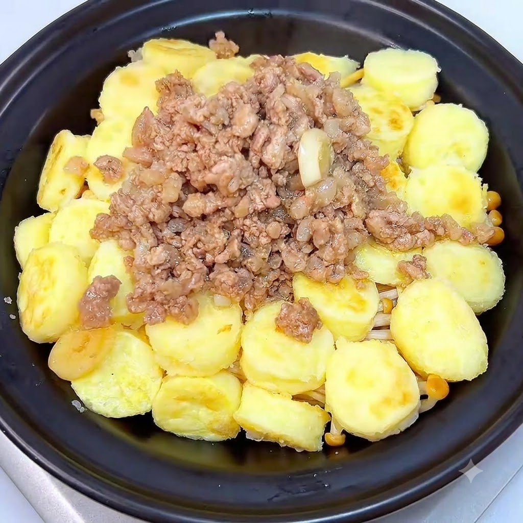 Un plat en terre cuite noir recouvert de son couvercle assorti posé sur une plaque de cuisson.