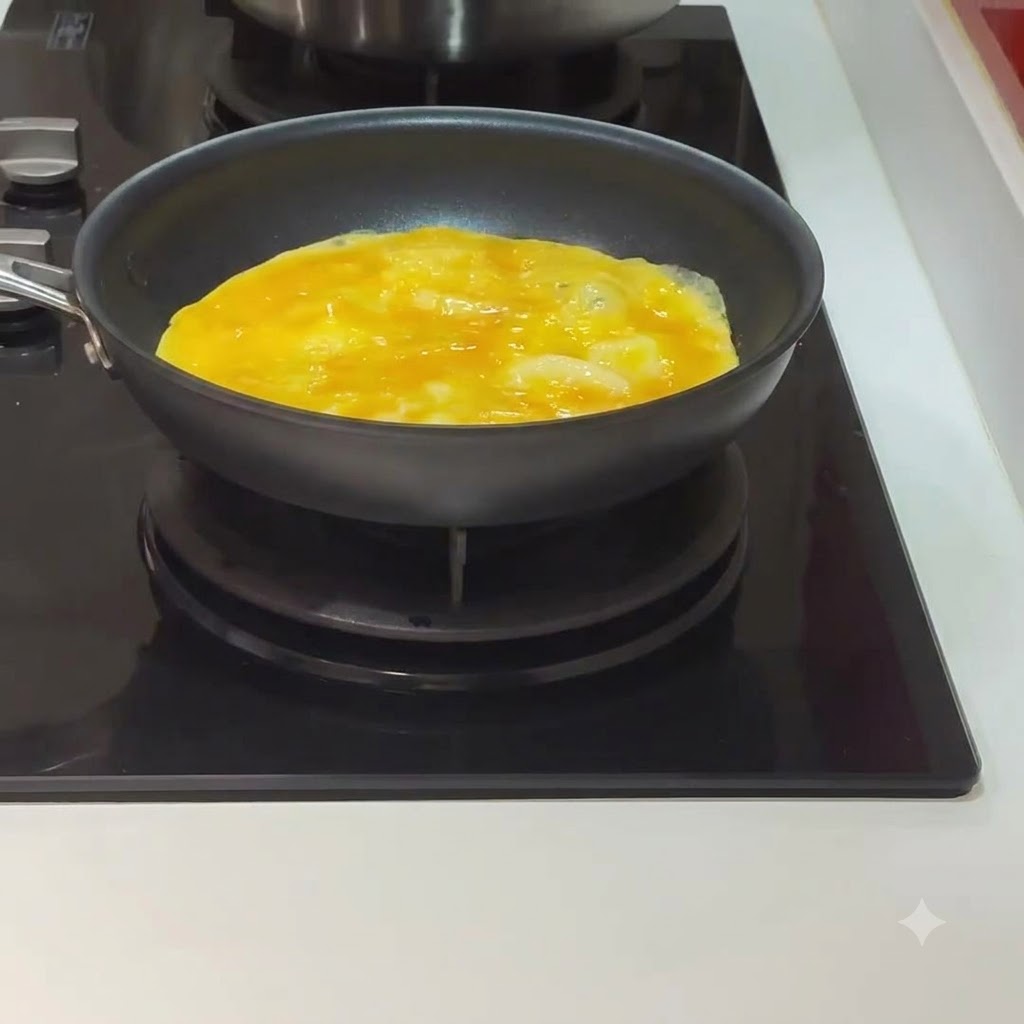 Un œuf en train de cuire et de commencer à prendre à lintérieur dune poêle noire sur une cuisinière.