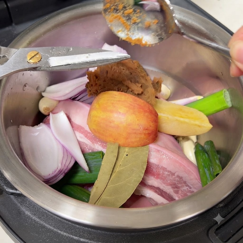 Une cuillère de pâte de soja coréenne brune ajoutée sur les ingrédients à lintérieur du pot de cuisson.