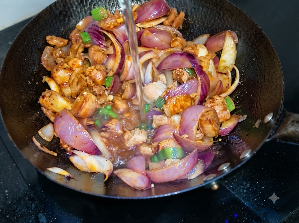 De leau versée par le dessus dans un wok contenant de la poitrine de porc sautée et des tranches doignon violet.