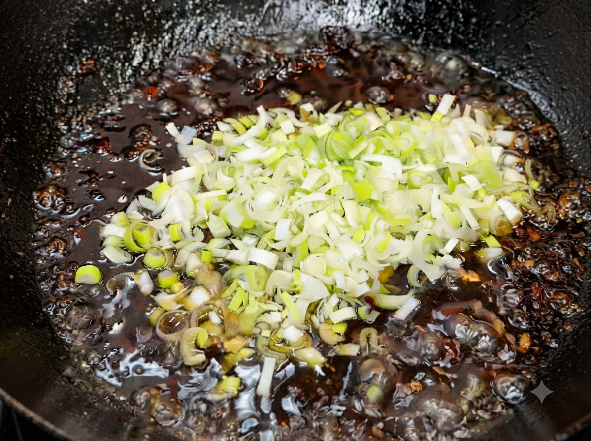 Oignons nouveaux verts fraîchement hachés mélangés à la sauce frite chaude et prête hors du feu.