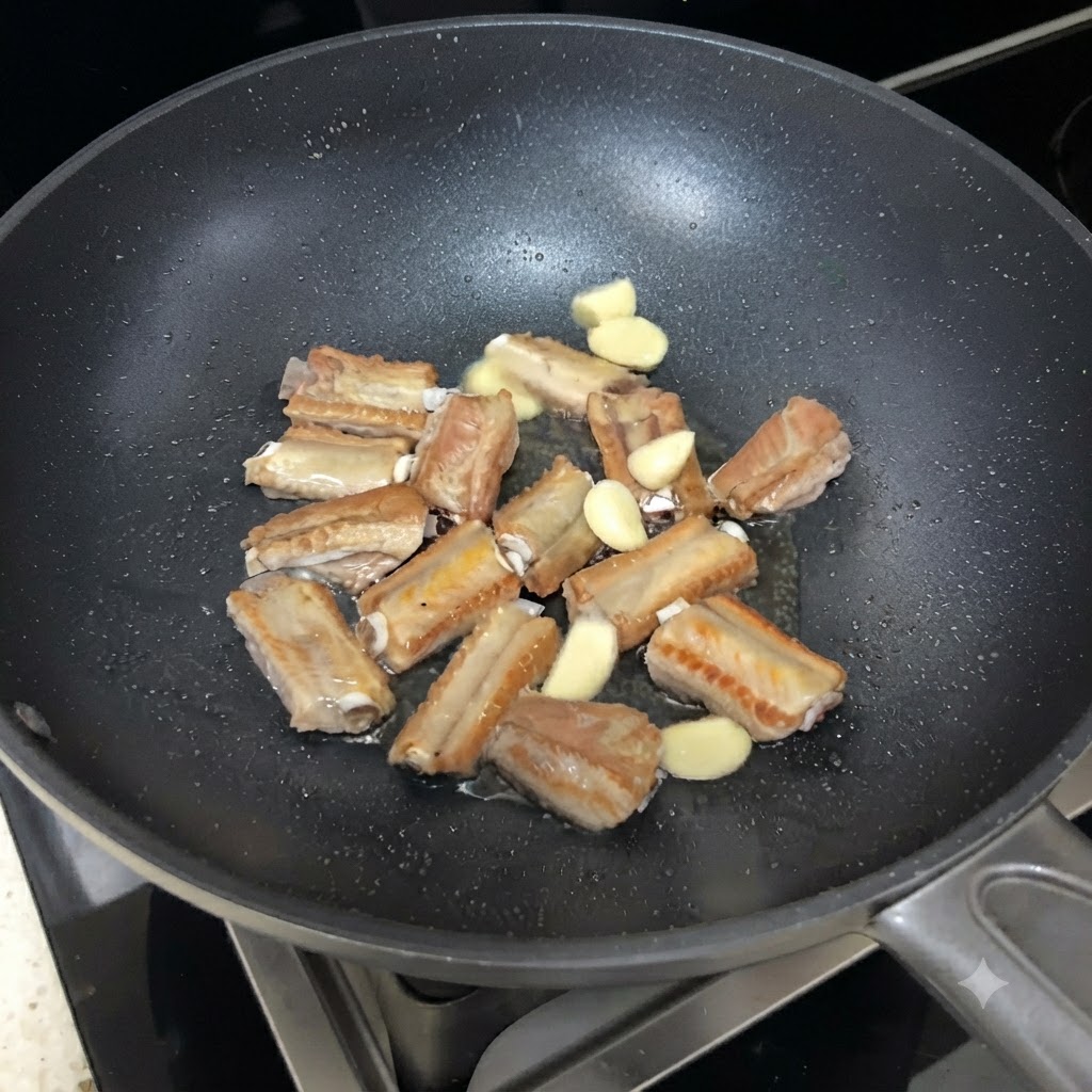 Tranches dail parsemées parmi les travers de porc saisis dans la poêle.