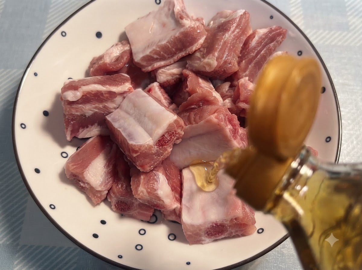 Du vin de cuisine versé dune bouteille sur des travers de porc crus disposés sur une assiette à motifs.