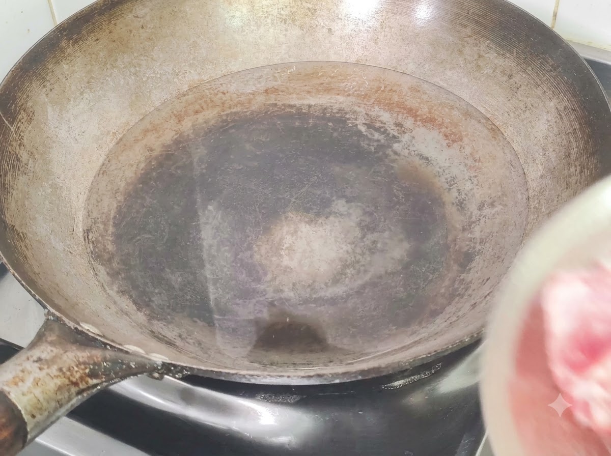 Travers de porc plongés dans un wok deau froide avec du gingembre et du vin de cuisine pour le blanchiment.