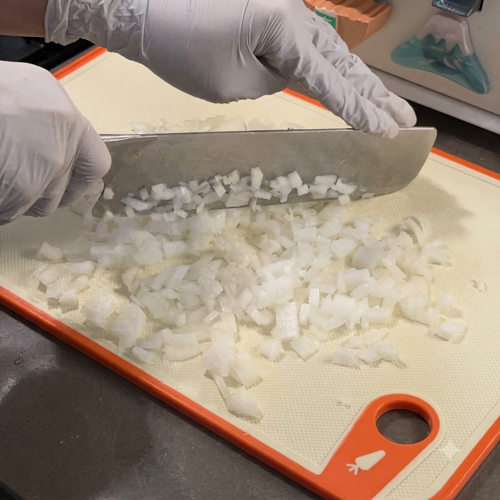 Oignons blancs finement émincés cuisant dans une poêle en fonte chaude.