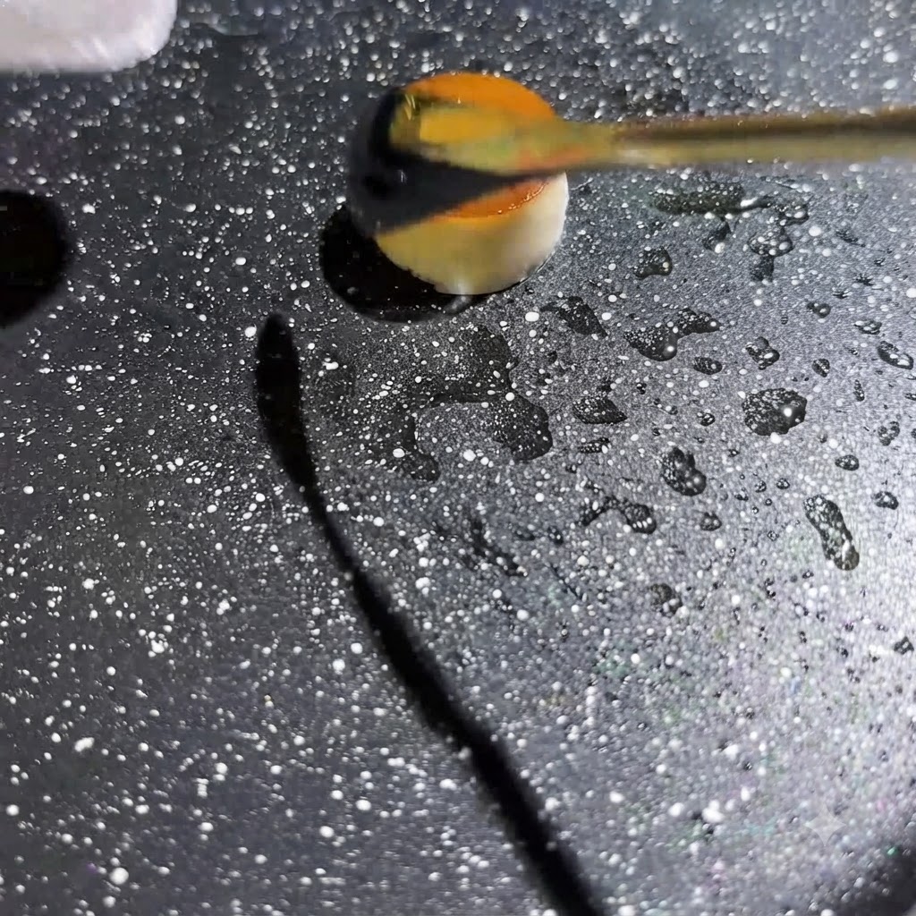 Du liquide dœuf jaune versé au centre dun petit anneau de champignon creux dans une poêle chaude et mouchetée.