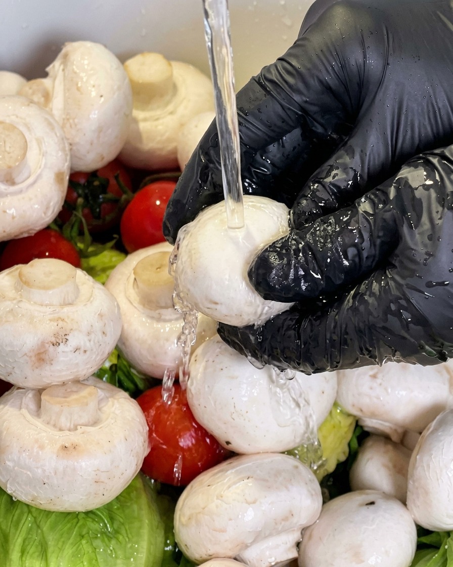 Un champignon de Paris rincé sous leau courante.