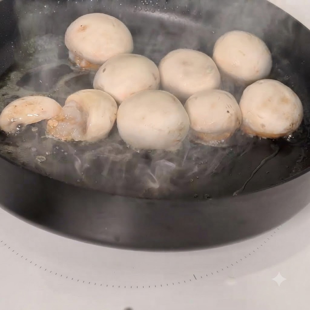 Chapeaux de champignons farcis aux crevettes en train de cuire dans une poêle chaude.