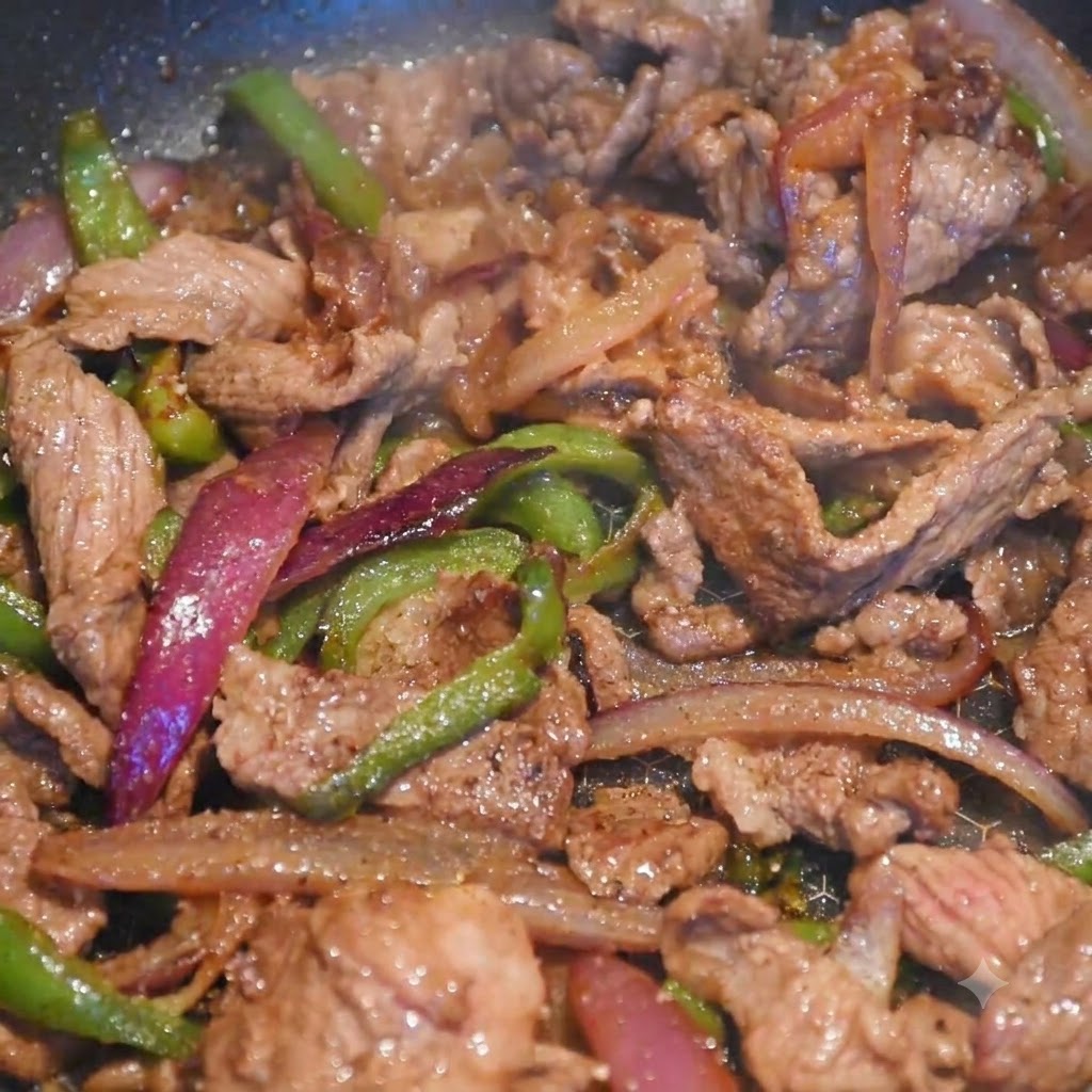 Des lanières de bœuf et de légumes colorés cuisant ensemble dans une poêle pendant que lon ajoute lassaisonnement.