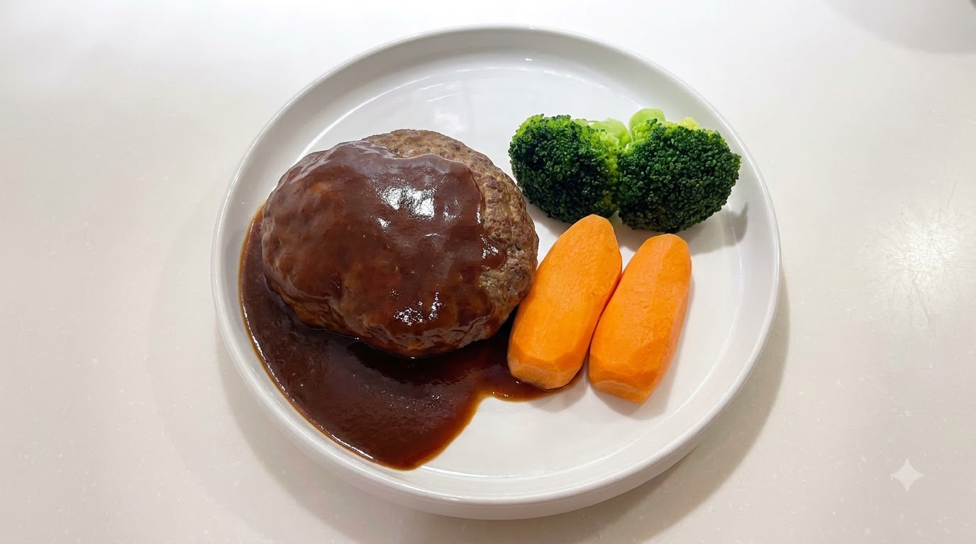 Un steak haché japonais juteux nappé dune sauce brune brillante, servi avec des carottes et du brocoli