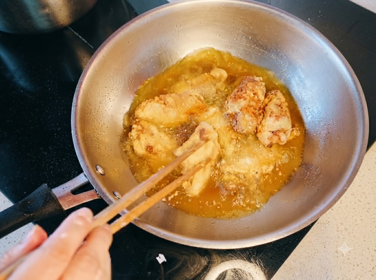 Ailes de poulet remuées et doublement frites dans lhuile chaude avec des baguettes.