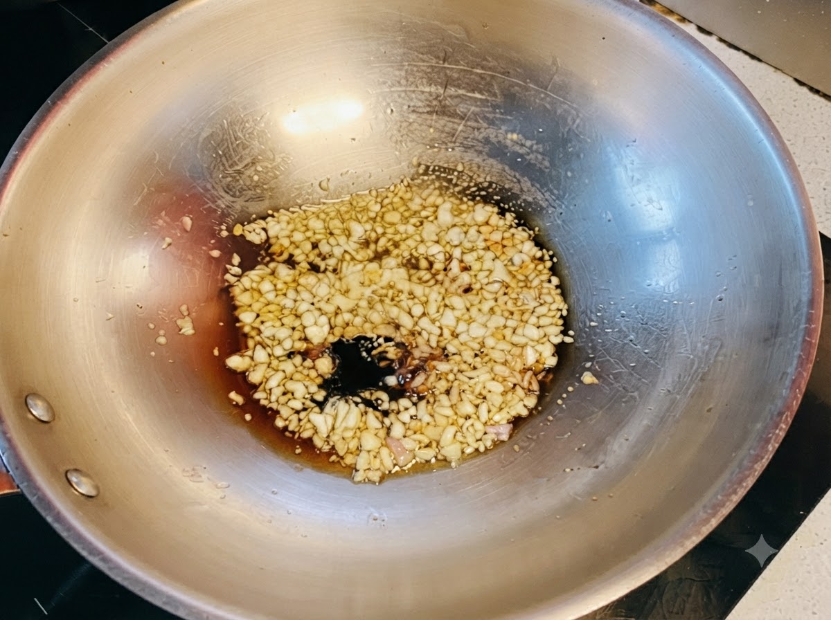 Sauces soja foncée et claire combinées avec du miel frémissant sur lail sauté dans le wok.
