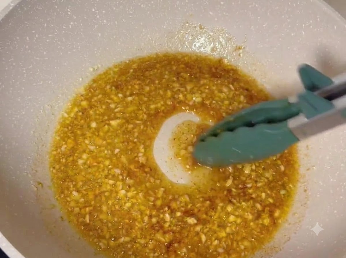 Des pilons de poulet frits enrobés dans un glaçage au beurre à lail frémissant à lintérieur dune poêle.